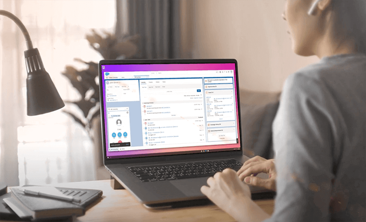 Vonage Business Communications now makes it easier than ever for companies who use Salesforce to streamline and personalize customer experiences.  Watch now! contact center agent at her desk with laptop open showing Vonage Business Communications embedded within Salesforce