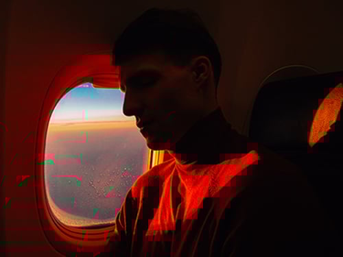Young Man Sleeping In Airplane Over Window Side view of young handsome male sleeping in aircraft over window with sunset