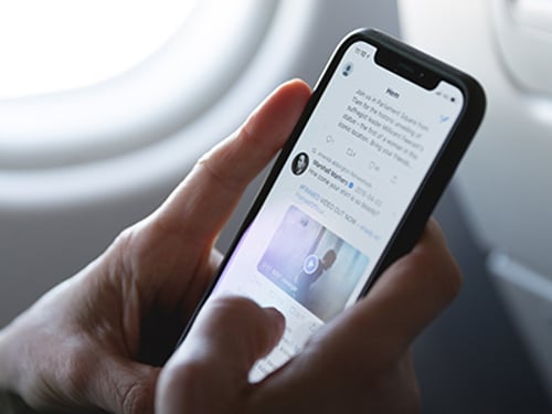 Smartphone in hands on airplane Image of a person using a smartphone on a plane.