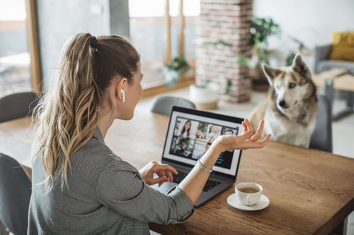 Generic integrations screenshot from Getty Women at home during pandemic isolation have conference  call, pet dog is with her